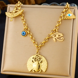 Detailed view of gold stainless steel necklace with Egyptian scarab and eye charms