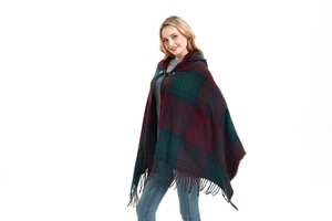 Detail of plaid hooded poncho featuring leather buckle closure and tassel hem trim