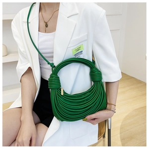 Dettaglio borsa a tracolla verde in pelle PU con nodi intrecciati e texture arricciata