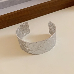 Minimalist silver open cuff bracelet with hammered texture and pleated metal design