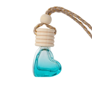 Heart-shaped glass car perfume bottle with blue liquid and wooden cap on white background
