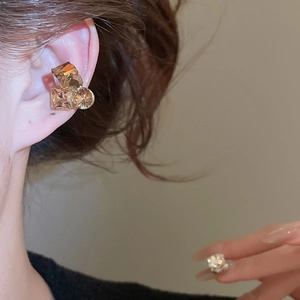 Detail shot of champagne gold geometric crystal ear cuff on model ear with sparkling finish
