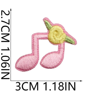 Macro view of pink musical note embroidery patch with yellow flowers and dimensions