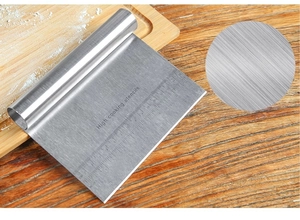 Detail of stainless steel dough scraper with precise inch and centimeter measurement scales