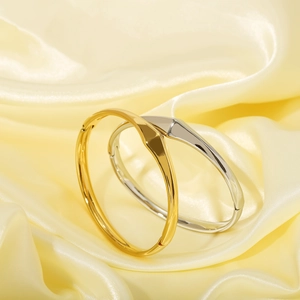 Minimalist geometric 18K gold and silver plated stainless steel bangles on silk cloth