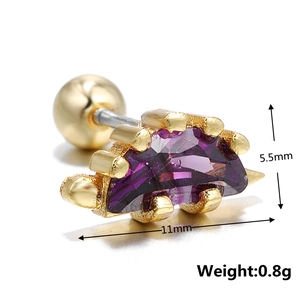 Macro shot of gold dinosaur cartilage stud with purple zircon and screw ball back