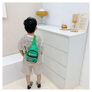 Child wearing green school bus crossbody chest bag with adjustable strap and zip pocket