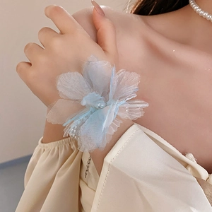 Close-up of model wearing a gradient blue fabric flower necklace with pearl details