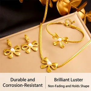 Detailed view of gold woven jewelry set with bow tie design and pearls on a tray