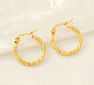 Macro shot of 18k gold plated twisted rope hoop earrings with high-polished texture