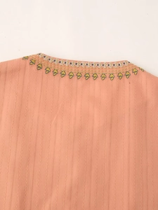 Close-up of pink ethnic vest showing vertical stripes and floral embroidery on neckline