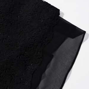 Vue macro détaillée de dentelle florale noire superposée sur un tissu en mousseline