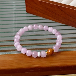 Detail of beaded bracelet with light purple translucent gems and orange agate accent