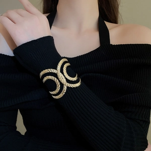 Detail view of gold sculptural spiral cuff bracelet featuring irregular textured patterns