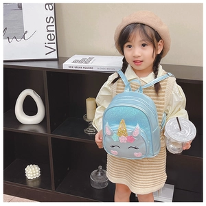 Close-up of blue sequined unicorn backpack with gold horn on a child model