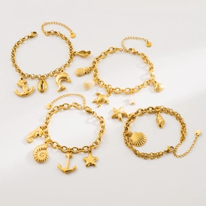 Detail view of four gold-tone marine theme bracelets with sea creature charms and lobster clasp