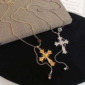 Detail of gold and silver cross necklaces with colorful rhinestones and leopard beads