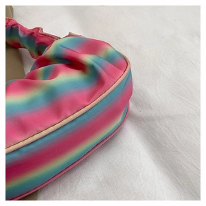 Macro detail of rainbow gradient pleated fabric on a women's shoulder dumpling bag