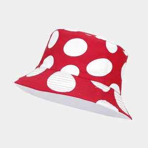 Close-up of a red and white polka dot reversible bucket hat with mushroom pattern style.