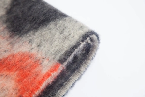 Macro detail of thick faux mohair scarf showing wavy jacquard knit and fuzzy texture