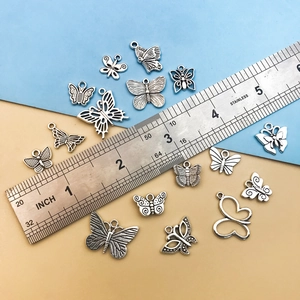 Silver butterfly alloy charms in various designs with ruler for size reference