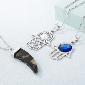 Three silver crystal necklaces featuring marble tusk and Hamsa hand pendants