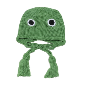 Close-up of green frog knit hat featuring cute big eyes and braided straps with tassels