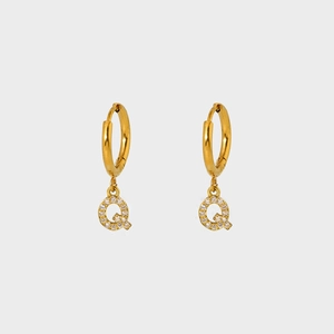 Detailed macro of gold plated stainless steel earring with pavé zircon letter Q charm