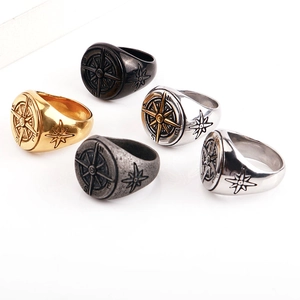 Macro shot showing five colors of retro compass rings with detailed N S E W engravings