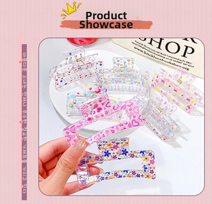 Close-up of clear acrylic hair claws featuring colorful floral and heart patterns