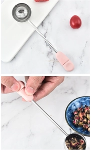 Roestvrijstalen thee-infuserlepel met roze draaibare handgreep en fijn maasfilter voor losse thee.
