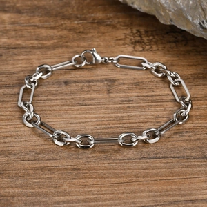 Detailed shot of silver stainless steel chain link bracelet on a natural rustic background