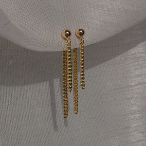 Macro shot of gold-plated S925 sterling silver tassel earrings with delicate metal chains