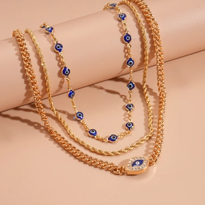 Detail view of gold layered necklaces with blue evil eye beads and rhinestone pendants