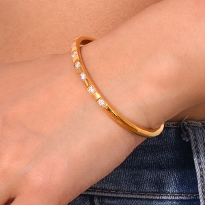 Detail of 18K gold-plated stainless steel bangle with pavé zirconia on wrist