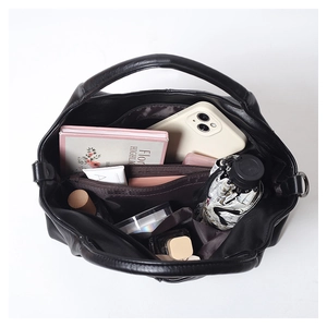 Top view of spacious black soft leather tote bag with compartments and daily essentials