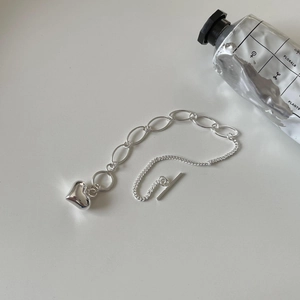 Detailed close-up of S925 sterling silver heart bracelet with sleek OT toggle clasp