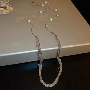 Detail of layered pearl necklace with silver metallic beads and dangling fine chains