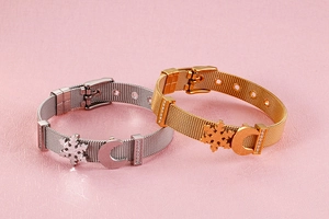 Dettaglio di bracciali a rete in acciaio inossidabile oro e argento con ciondoli luna e neve