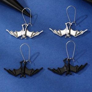 Detailed close-up of gothic bat pendant earrings in silver and black metal finishes