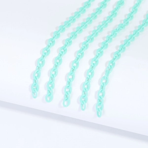 Detail shot of light green acrylic jewelry chains arranged on a clean white background