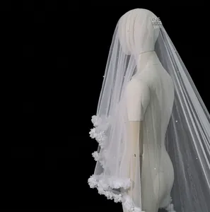 Detail of white bridal veil featuring delicate 3D lace flowers and pearl embellishments