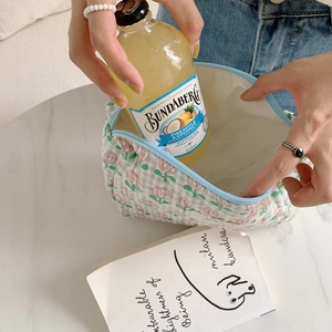 Quilted floral makeup bag detail showing large capacity compared to a 375ml bottle