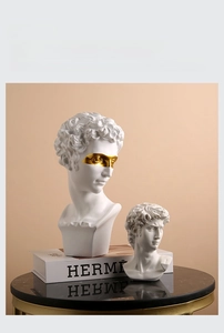 Classical Greek statue resin ashtray with gold mask detail on dark marble surface