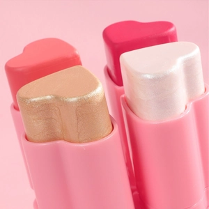 Makroaufnahme von herzförmigen Rouge-Stifts in mattem Pfirsich und schimmerndem Rosa