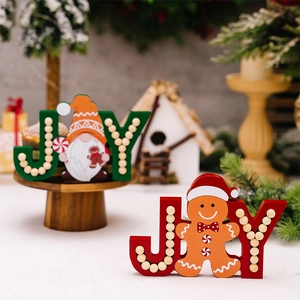 Detail of wooden JOY letter signs with gingerbread man and gnome Christmas tabletop decor