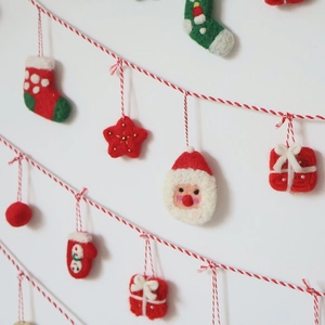 Handmade wool felt Christmas ornaments with Santa, snowman and festive bell icons