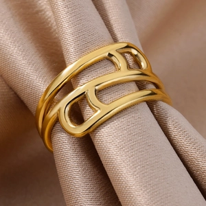 Macro detail of 18k gold plated stainless steel hollow geometric ring on satin fabric