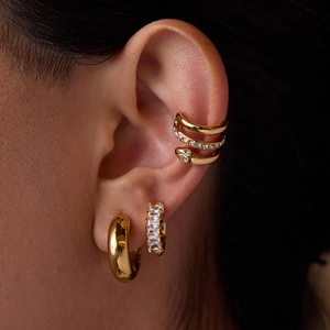 Close-up of gold snake earrings and ear cuff set with zircon stones on model
