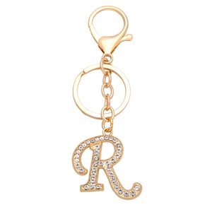 Macro detail of golden letter R keychain pendant with white rhinestones and clasp